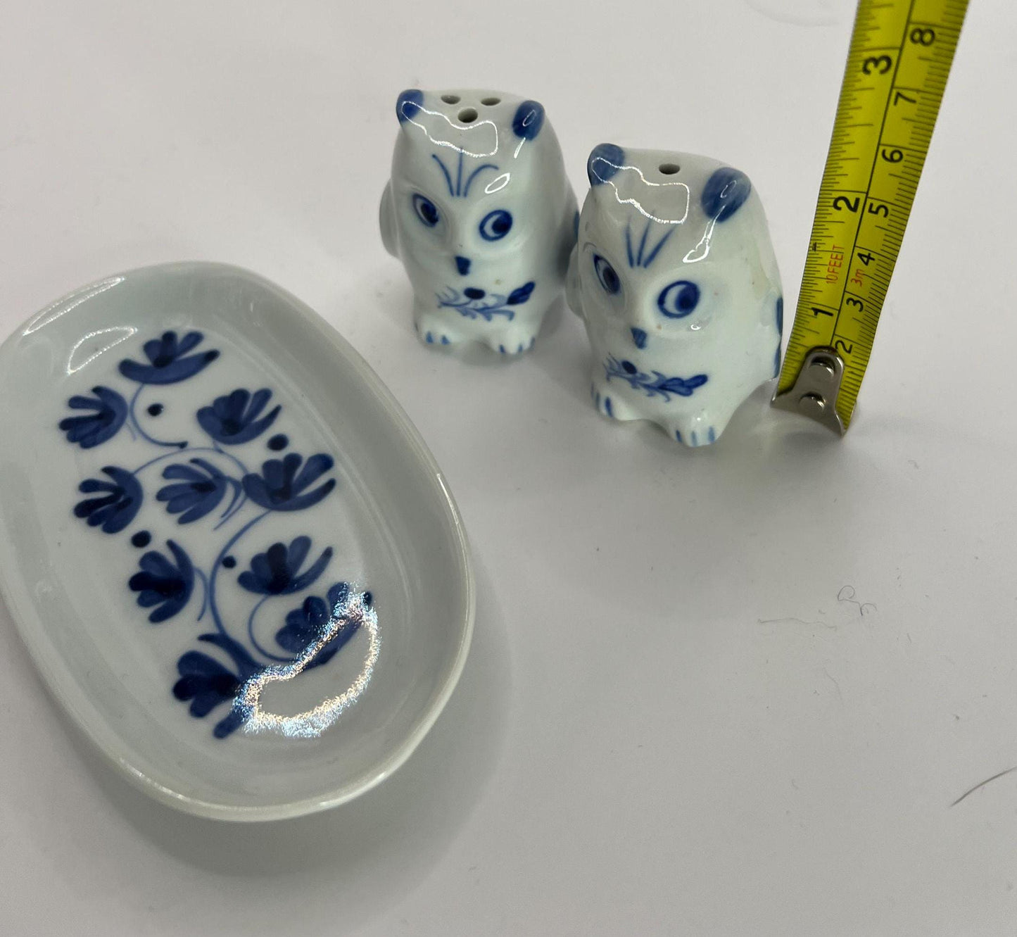 Tiny owl salt and pepper shakers on an oval plate.