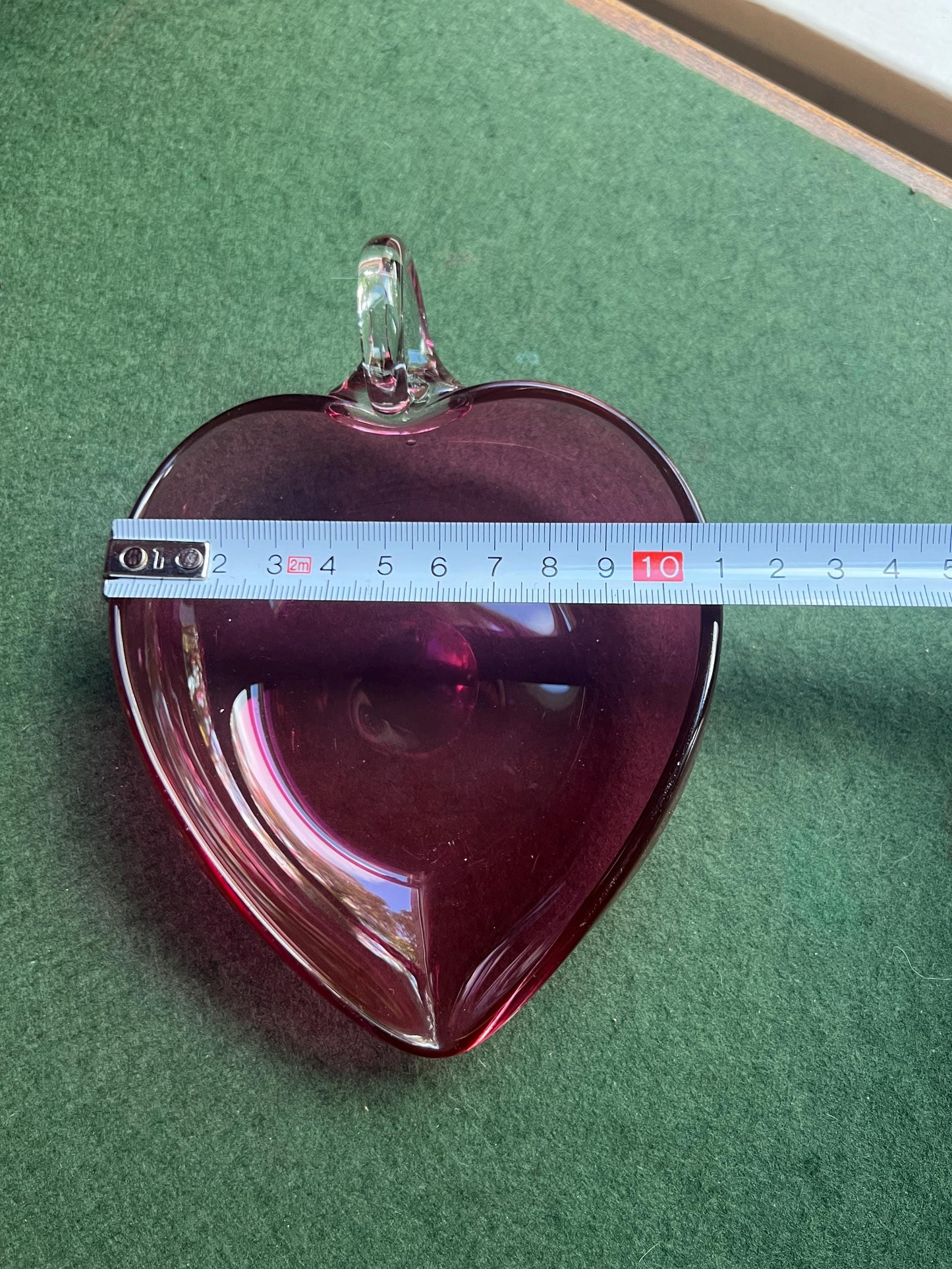 Hand blown cranberry glass heart shaped trinket dish. Applied clear handle.