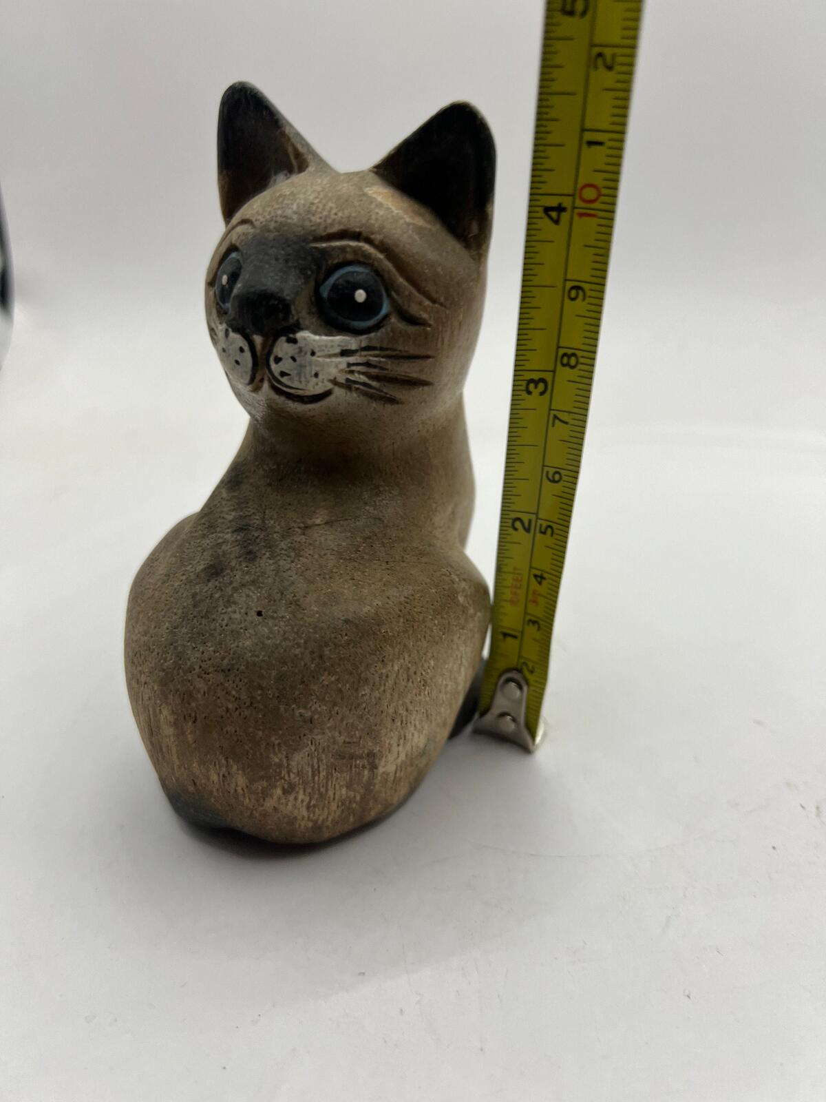 Vintage hand carved wooden quirky cat kitten figurine looking over its shoulder.