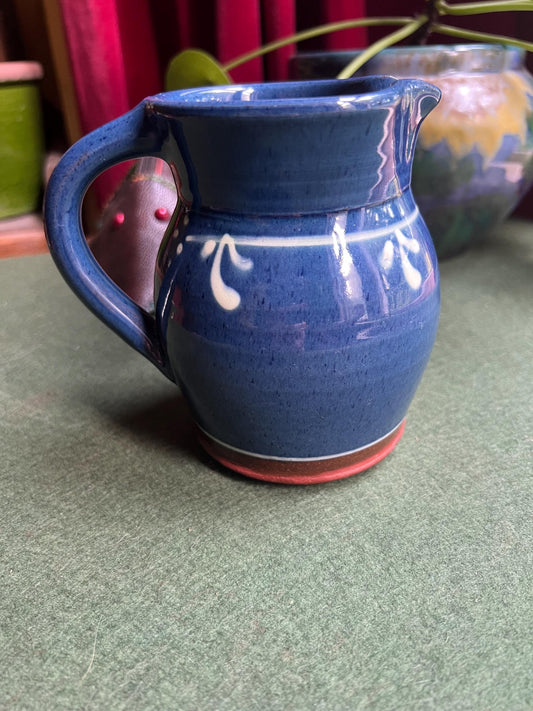 Studio pottery terracotta blue glazed milk water jug. White leaf detail.