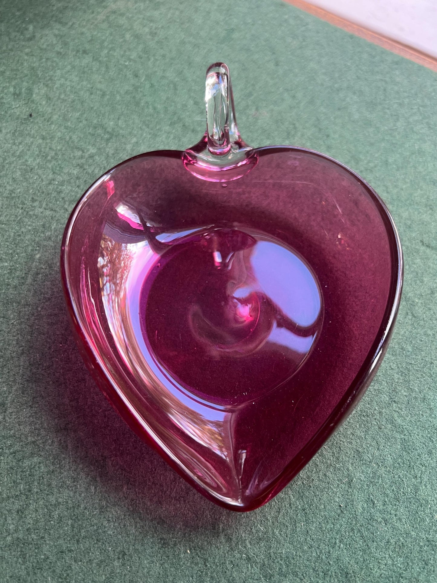 Hand blown cranberry glass heart shaped trinket dish. Applied clear handle.