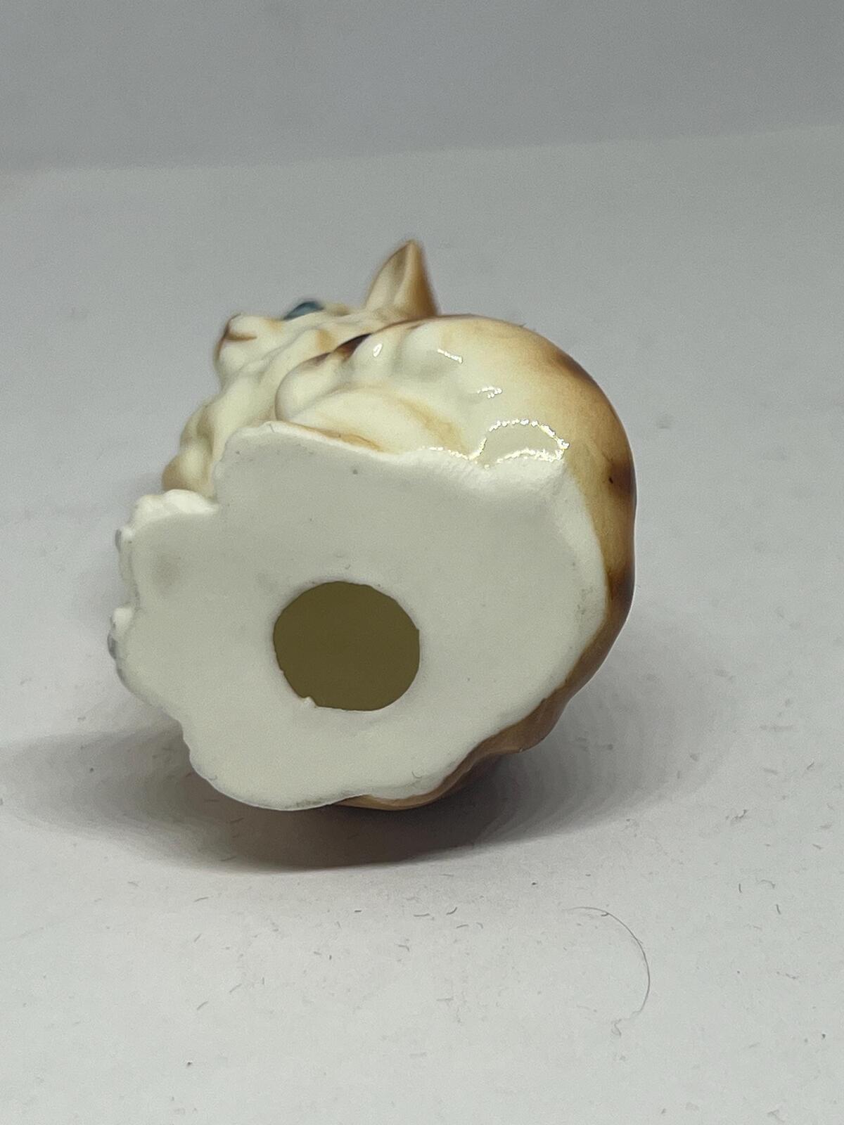 Miniature hand-painted porcelain cat figurine with blue eyes and a tabby calico pattern.
