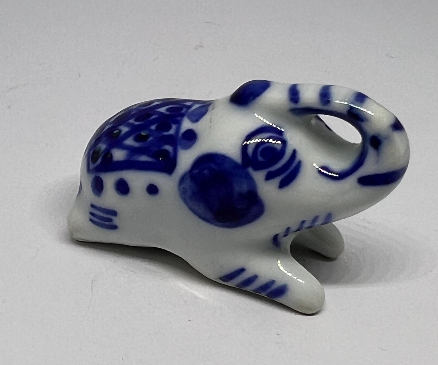Blue white ceramic elephant figurine. Lucky trunk up sitting elephant ornament.