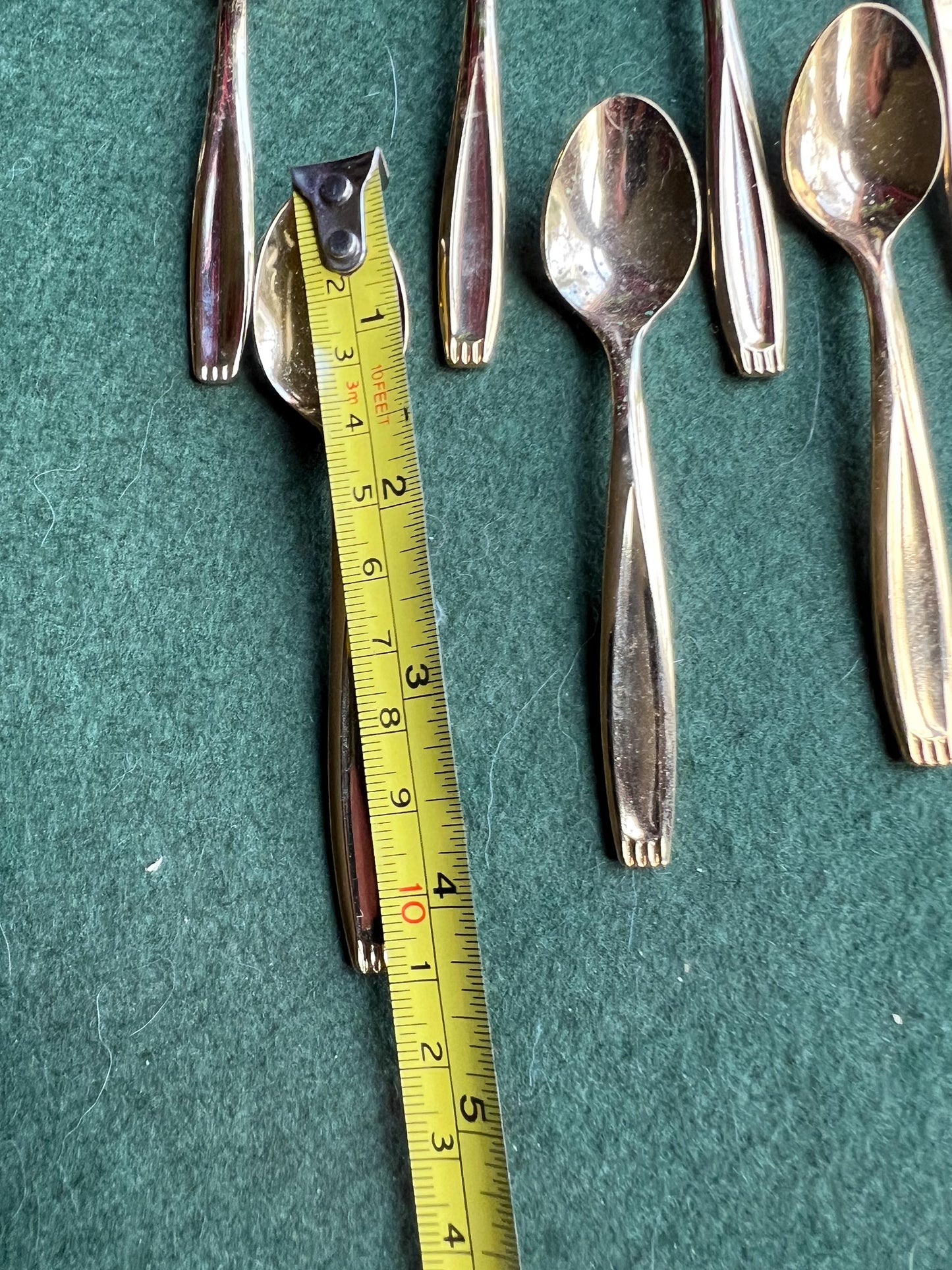 Set of seven Bronze plated sugar spoons with quirky handle end pattern.