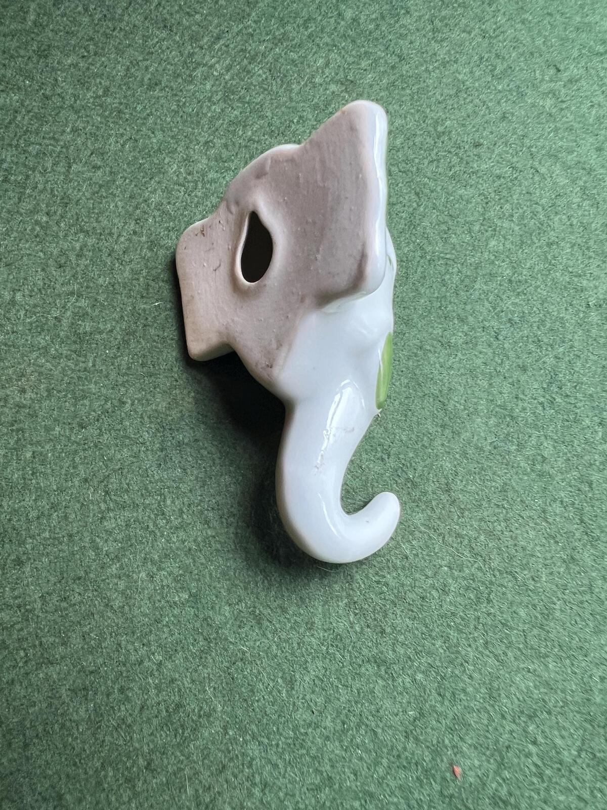 Vintage ceramic elephant head wall hanging. Hand painted green details.