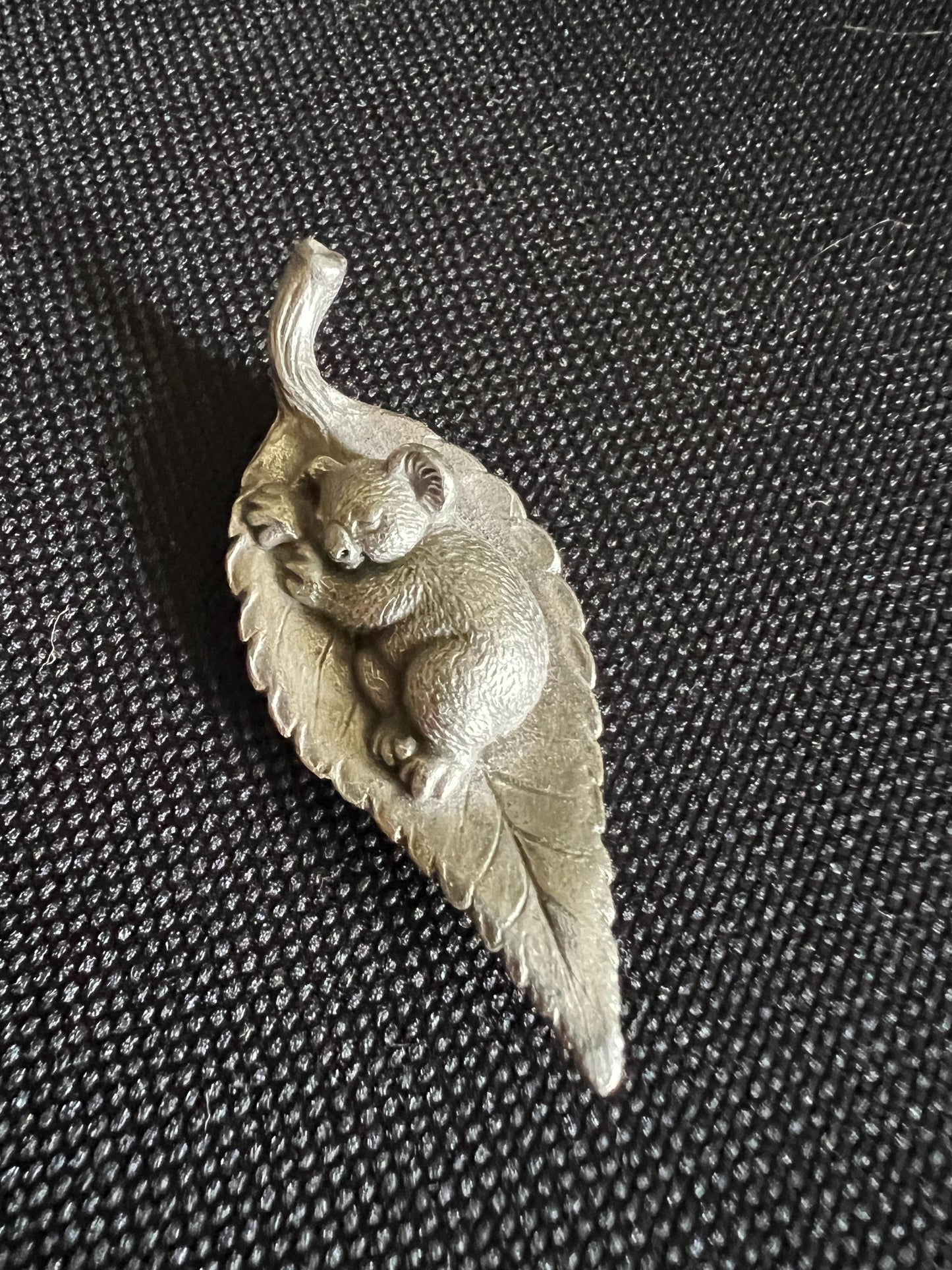 Tiny koala sleeping on a leaf. Pewter miniature figurine.