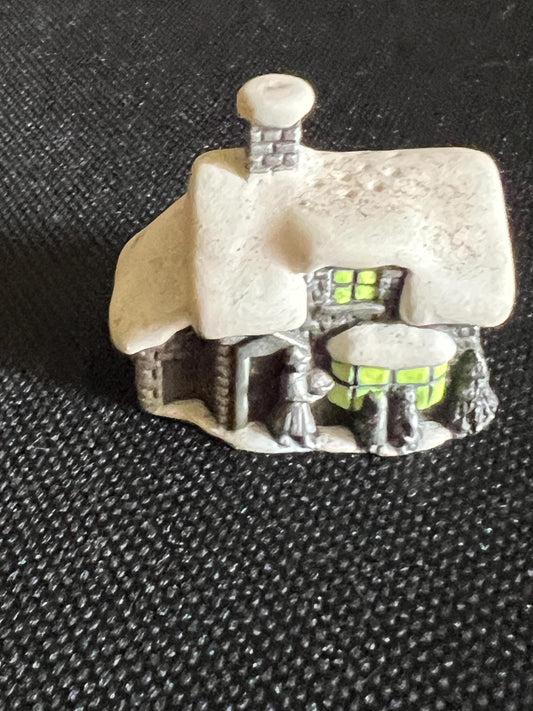 Miniature solid metal cast ornament snow covered Victorian shop.