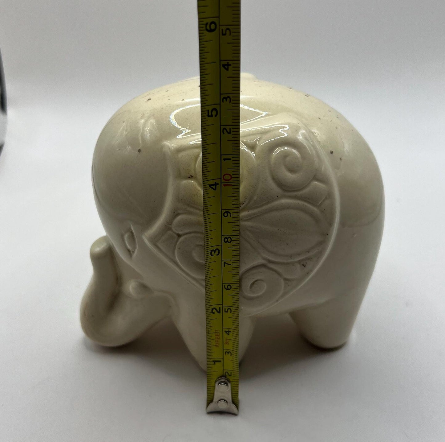 Quirky ceramic elephant figurine with decorated ears.