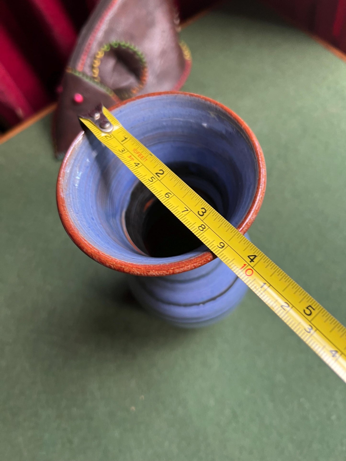 Beautiful vintage studio pottery vase. Blue glaze with black swirl and red rim. Stamped WOLD