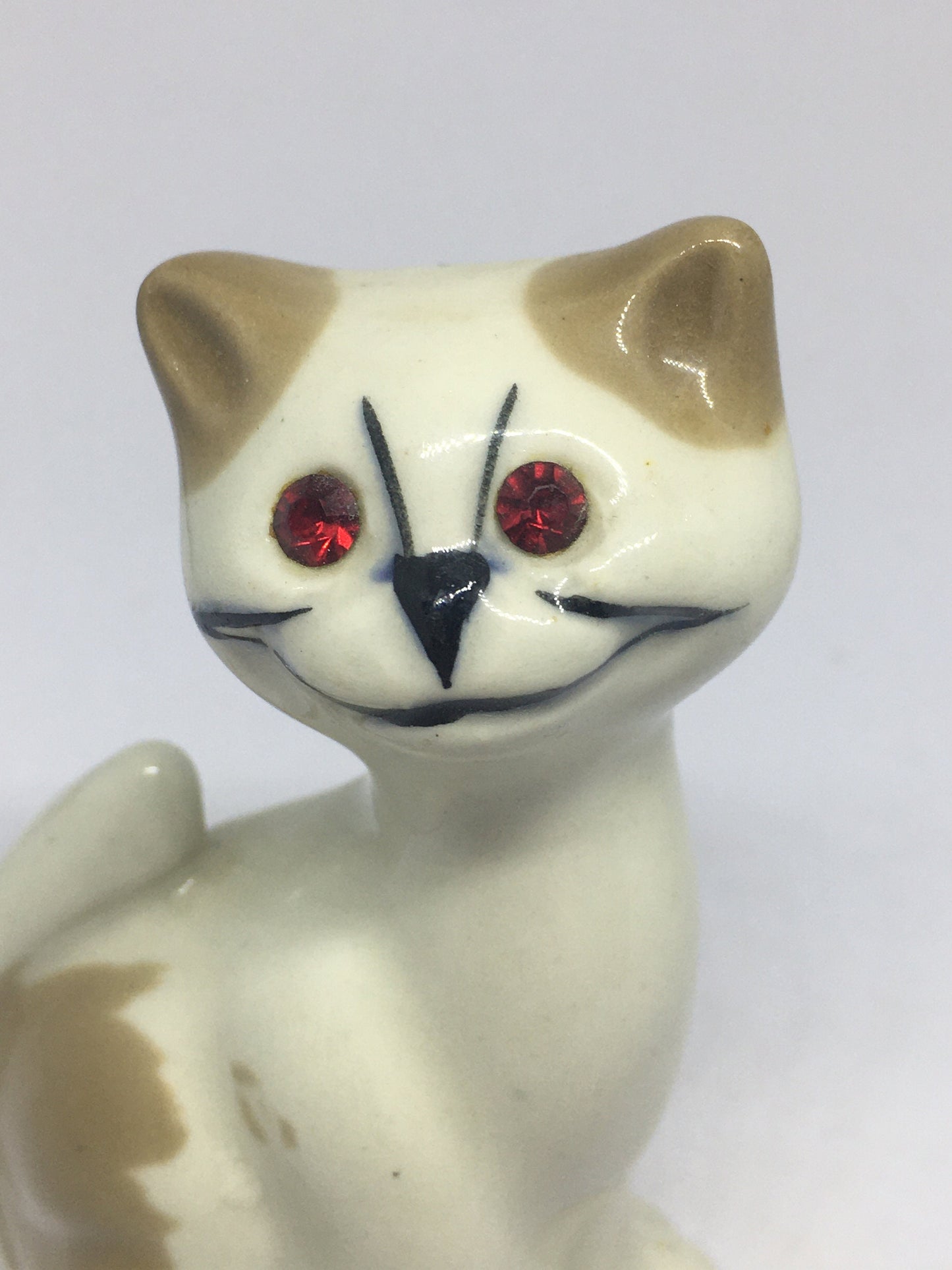 Red eyed smiling ceramic cat figurine. Stamped Weetman Giftware.