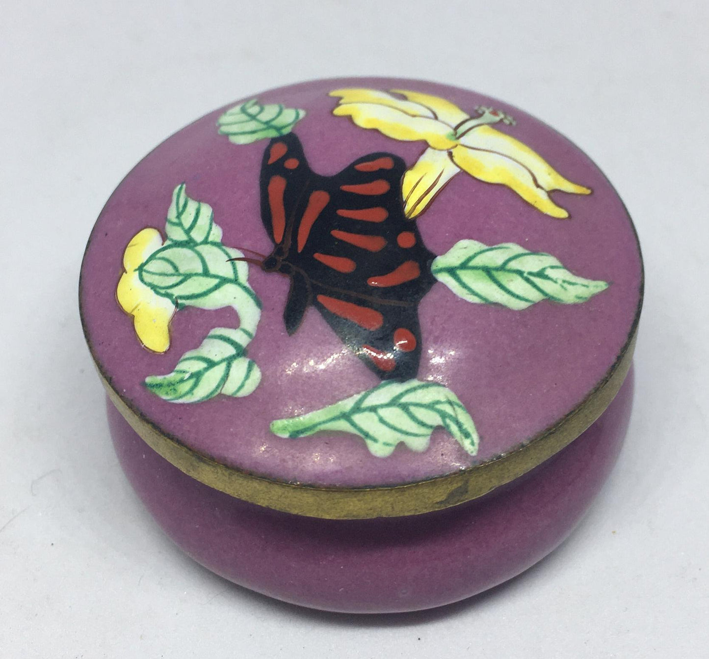 Enamel cloisonne lidded trinket box. Purple enamel with butterfly and flower decoration.