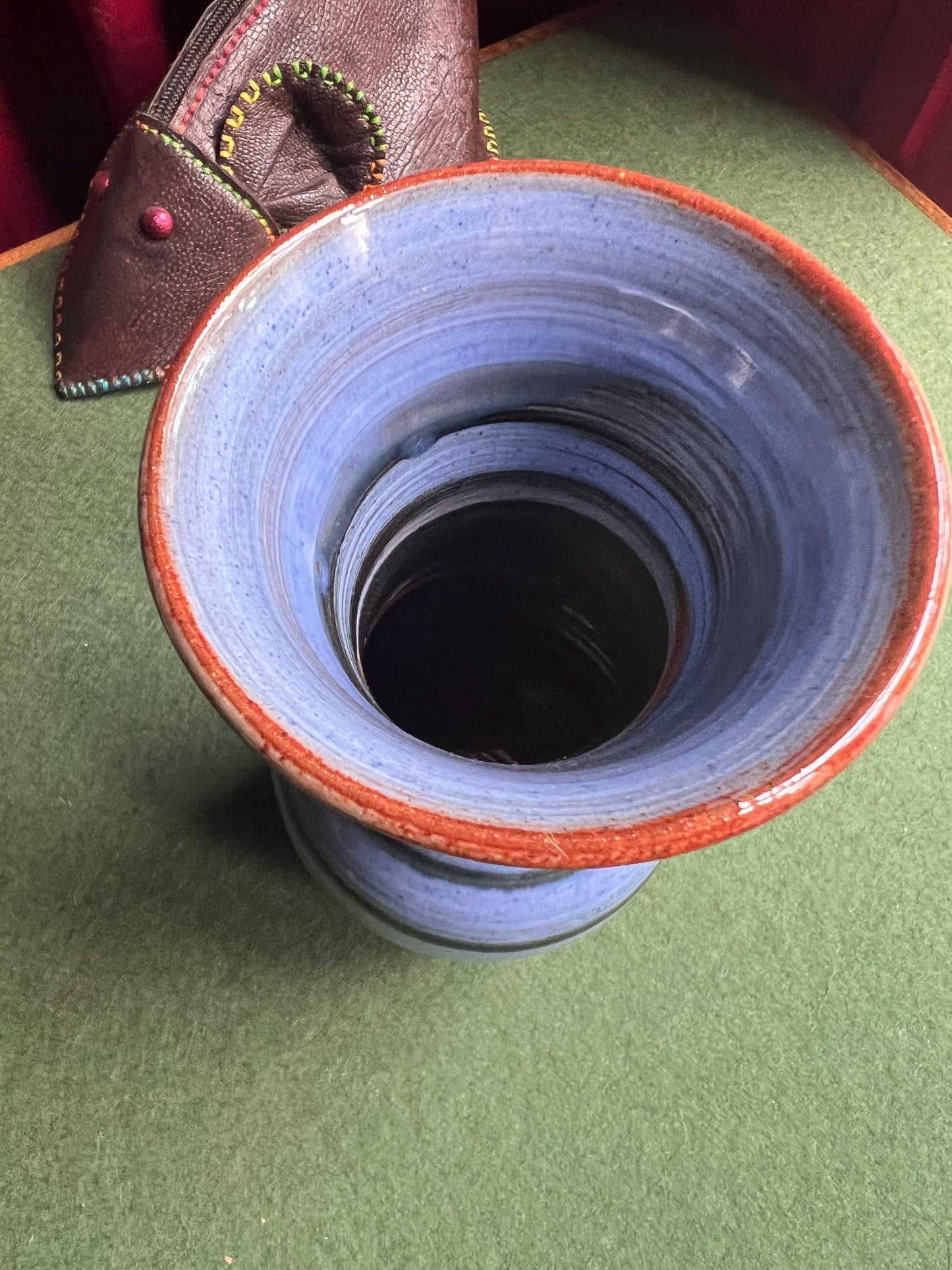 Beautiful vintage studio pottery vase. Blue glaze with black swirl and red rim. Stamped WOLD