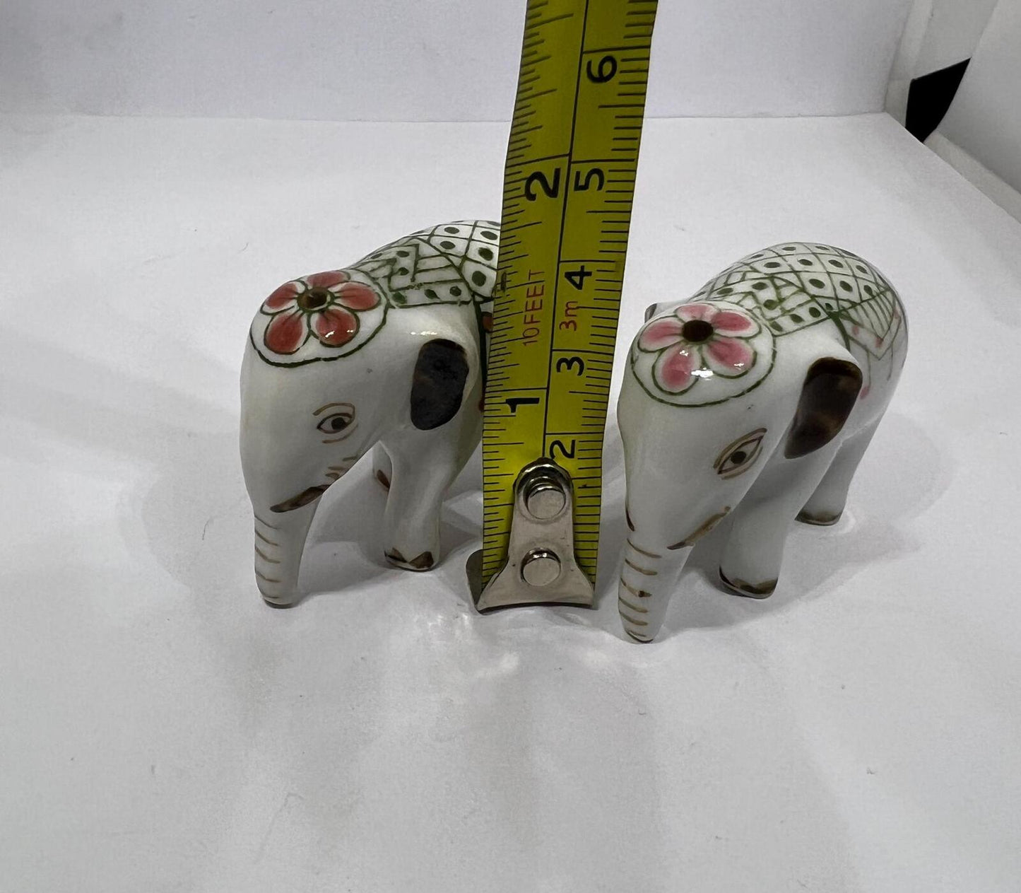 Tiny pair ceramic elephants. Mini ceremonial dress with floral headdress