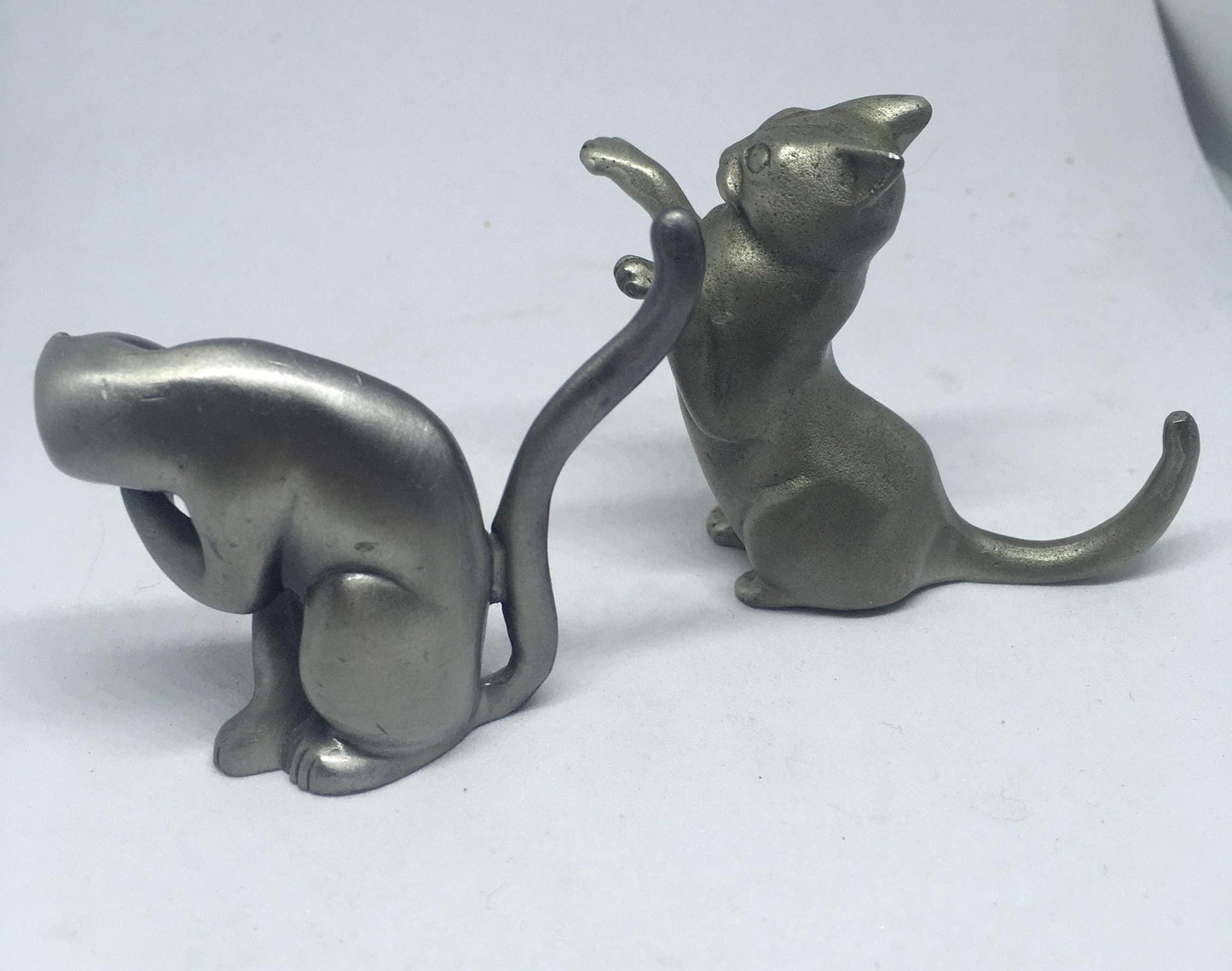 Two pewter cats.