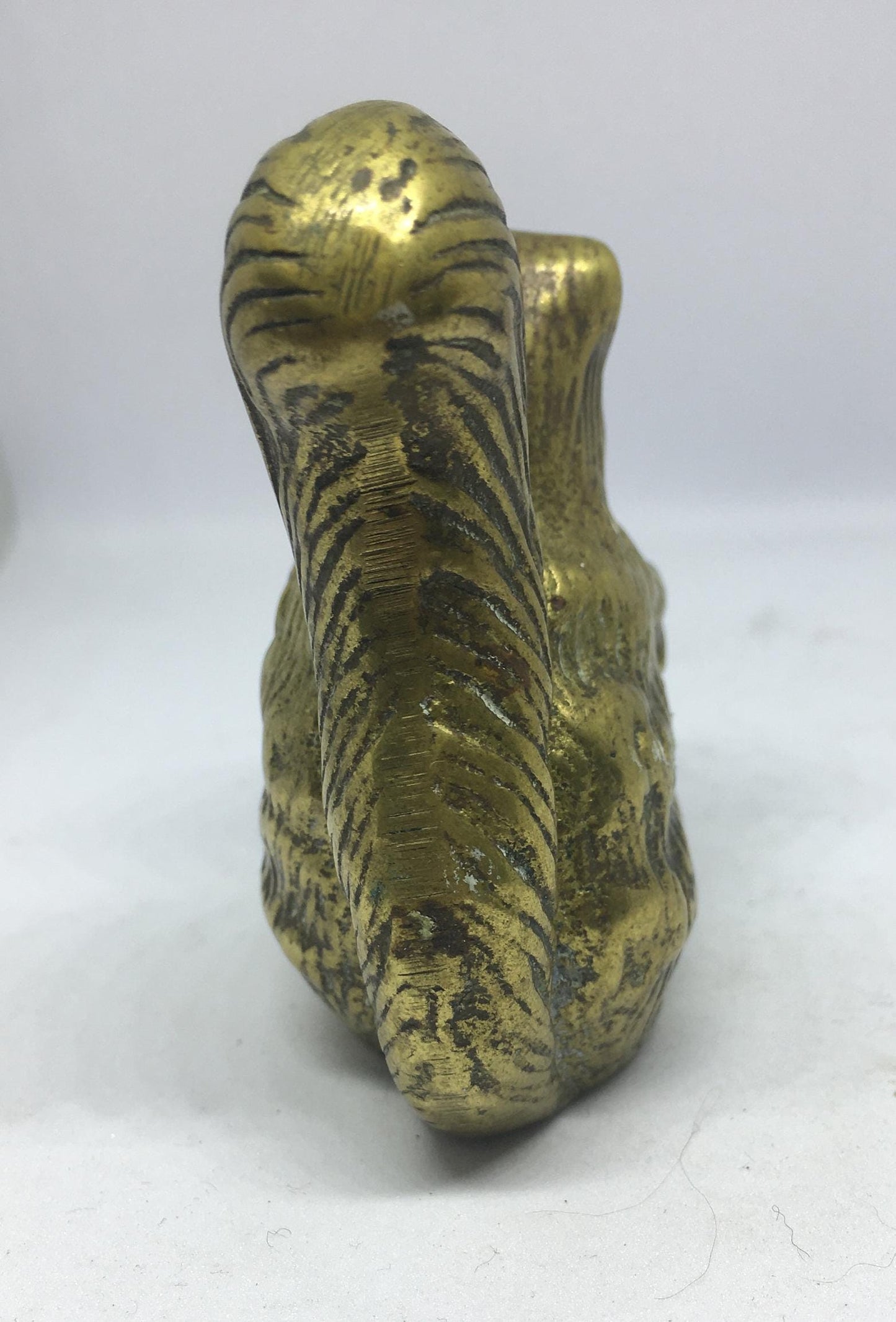 Vintage solid brass squirrel holding a nut.
