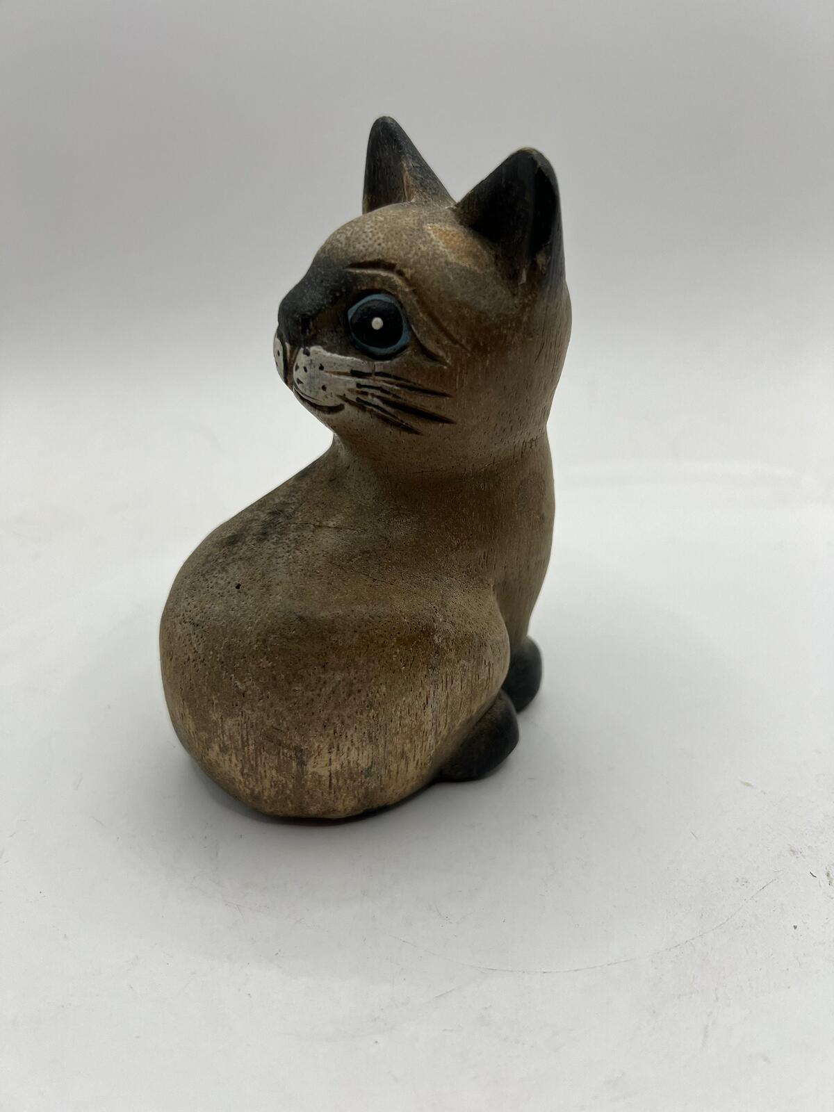 Vintage hand carved wooden quirky cat kitten figurine looking over its shoulder.