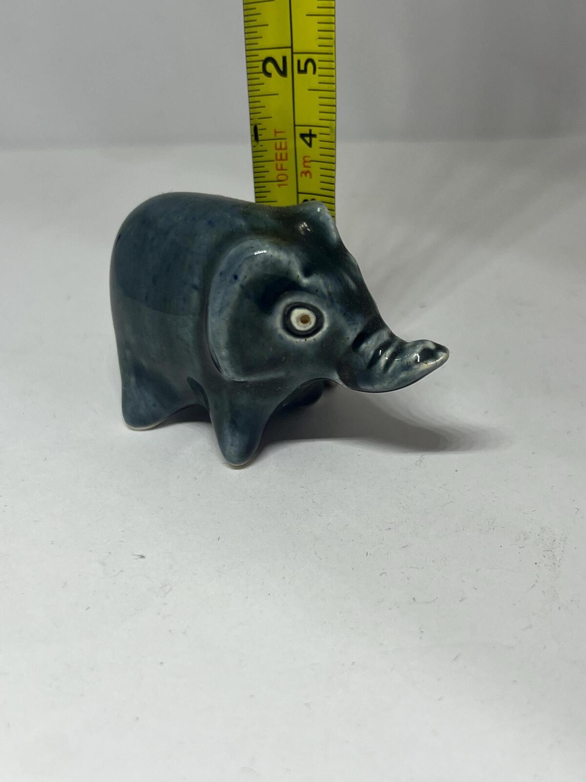Tiny elephant figurine. Wellow pottery Blue green glaze stylised baby elephant.
