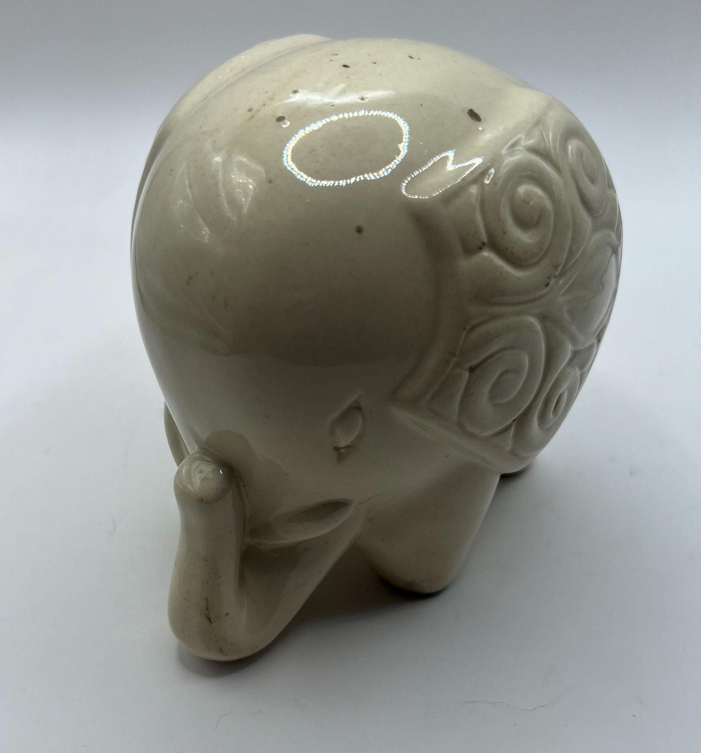 Quirky ceramic elephant figurine with decorated ears.