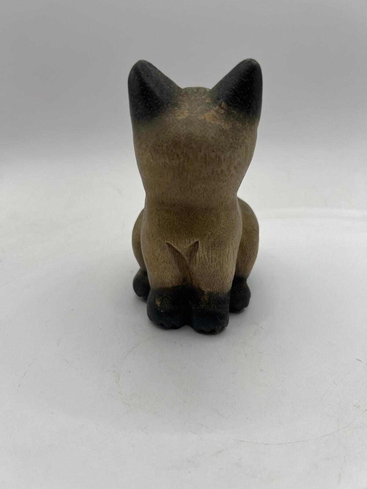 Vintage hand carved wooden quirky cat kitten figurine looking over its shoulder.