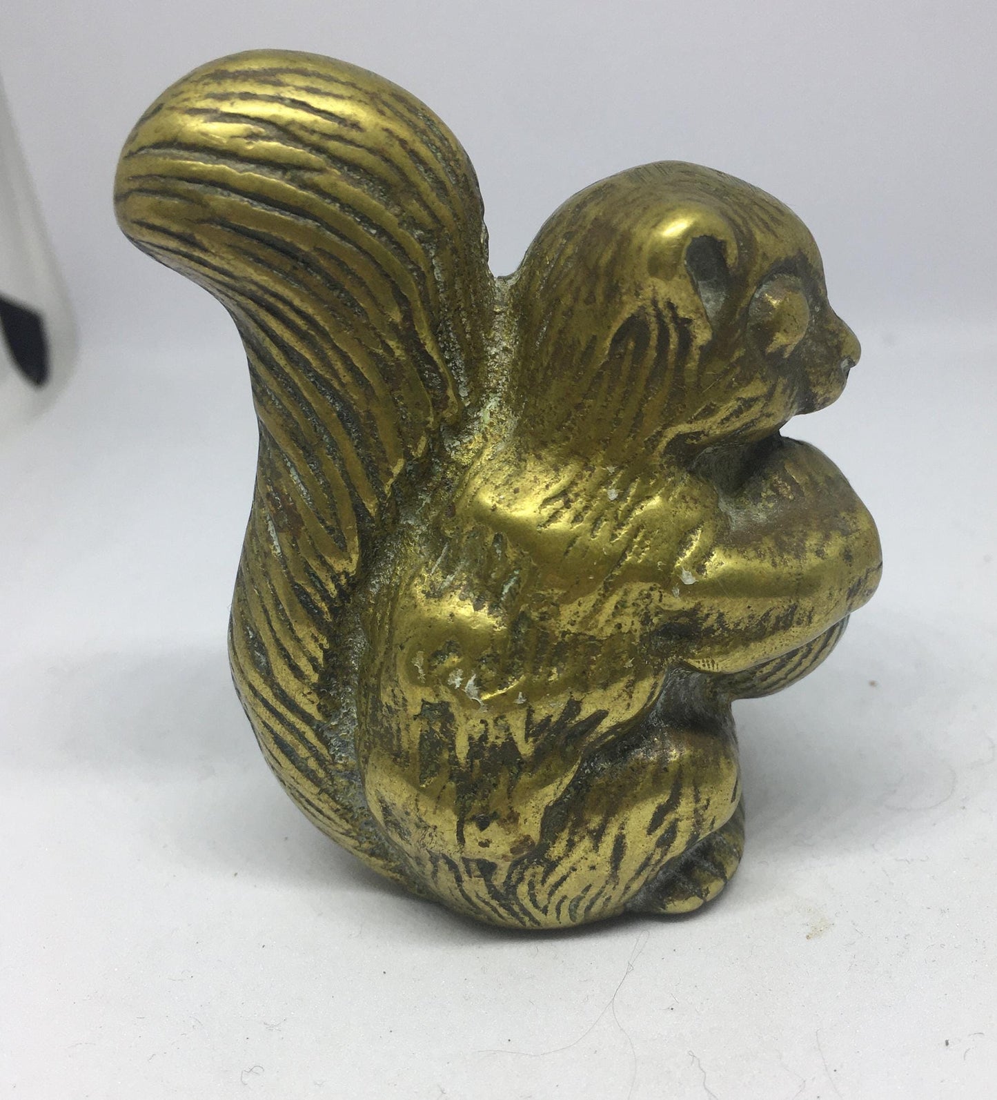 Vintage solid brass squirrel holding a nut.