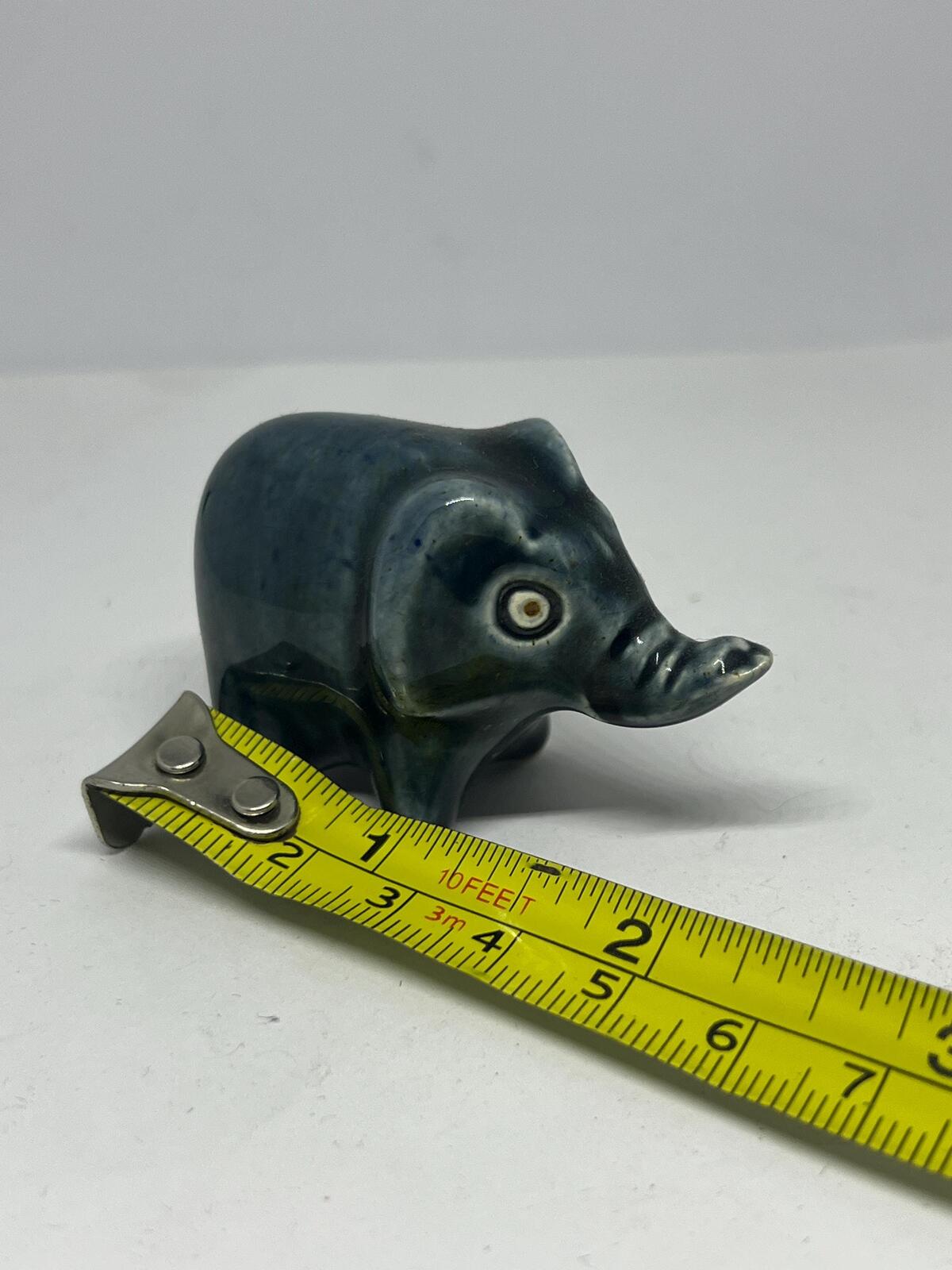 Tiny elephant figurine. Wellow pottery Blue green glaze stylised baby elephant.