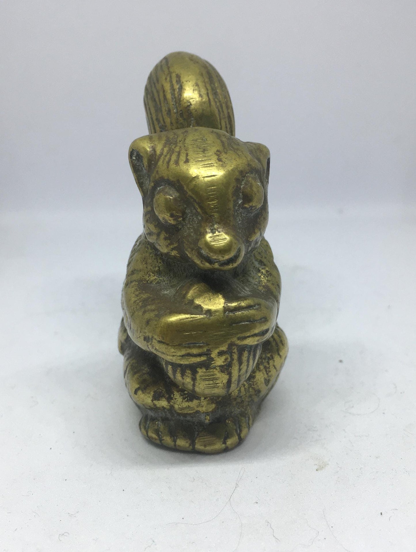 Vintage solid brass squirrel holding a nut.