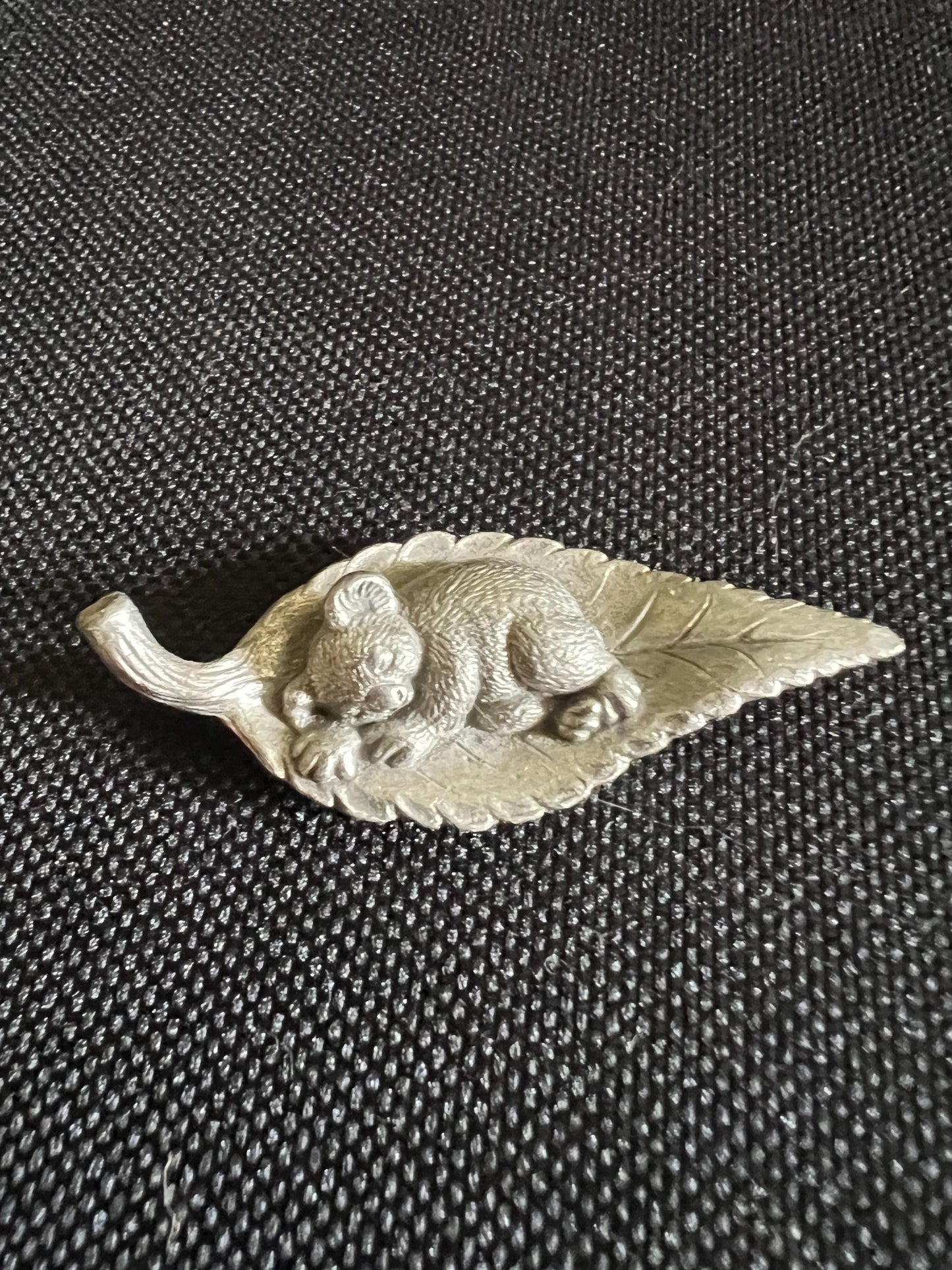 Tiny koala sleeping on a leaf. Pewter miniature figurine.