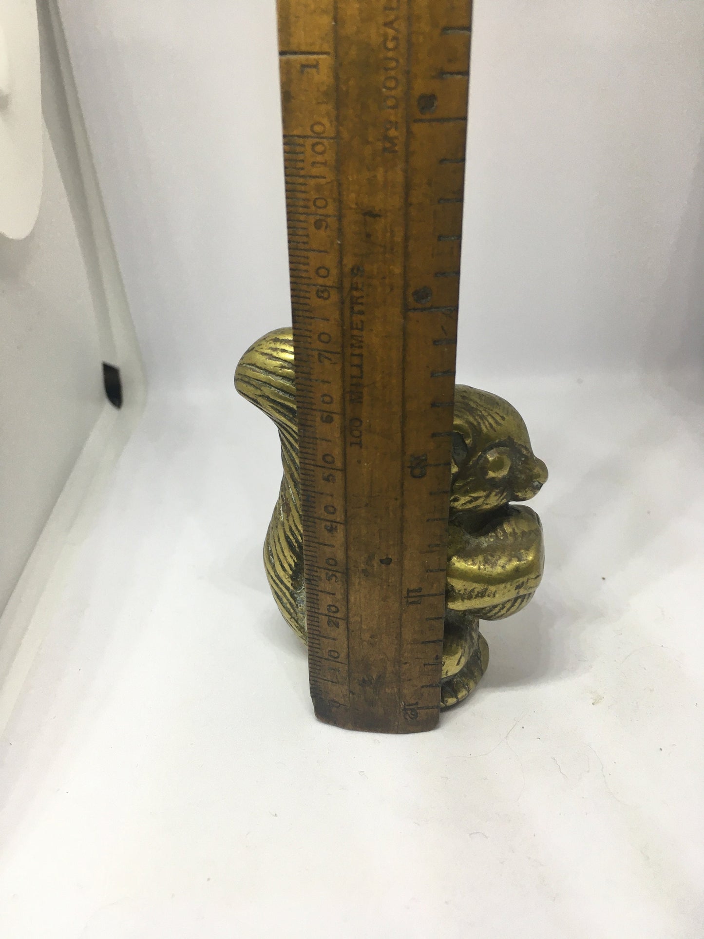 Vintage solid brass squirrel holding a nut.