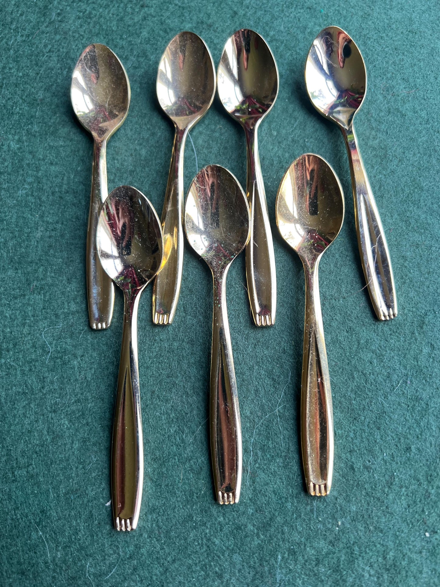 Set of seven Bronze plated sugar spoons with quirky handle end pattern.