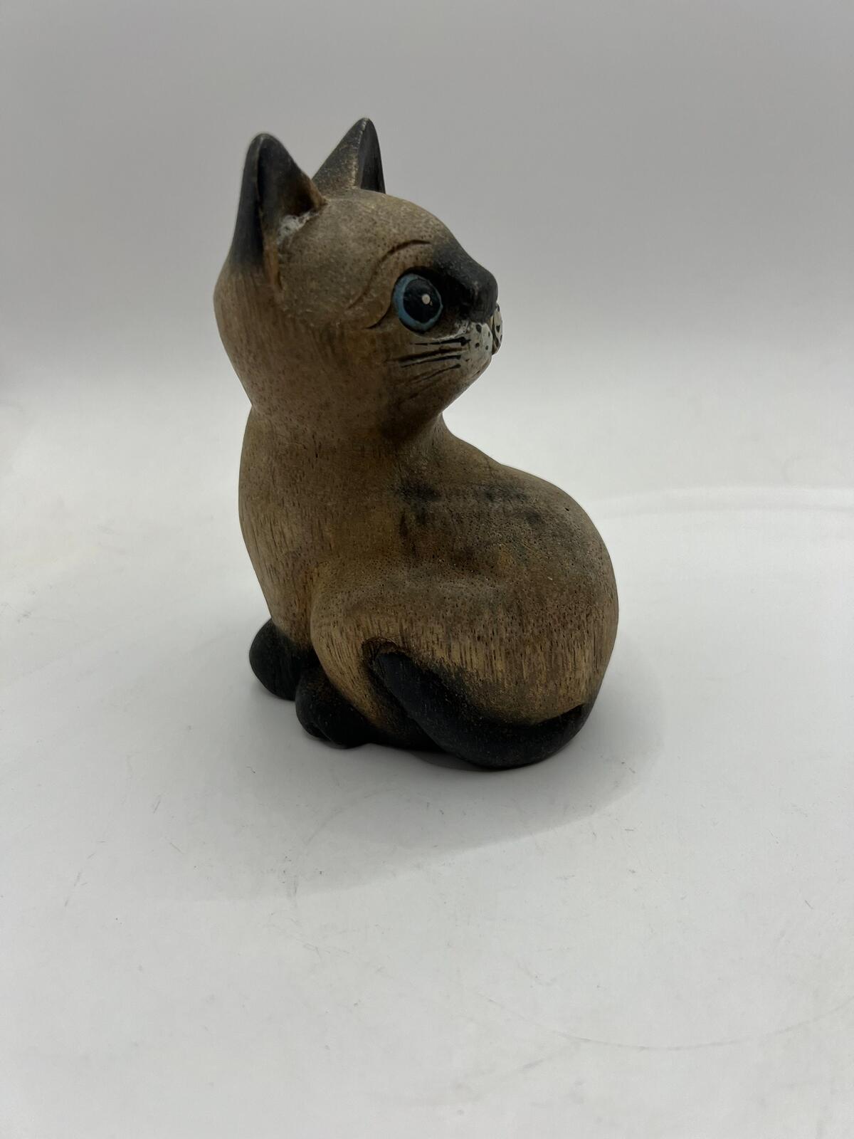 Vintage hand carved wooden quirky cat kitten figurine looking over its shoulder.