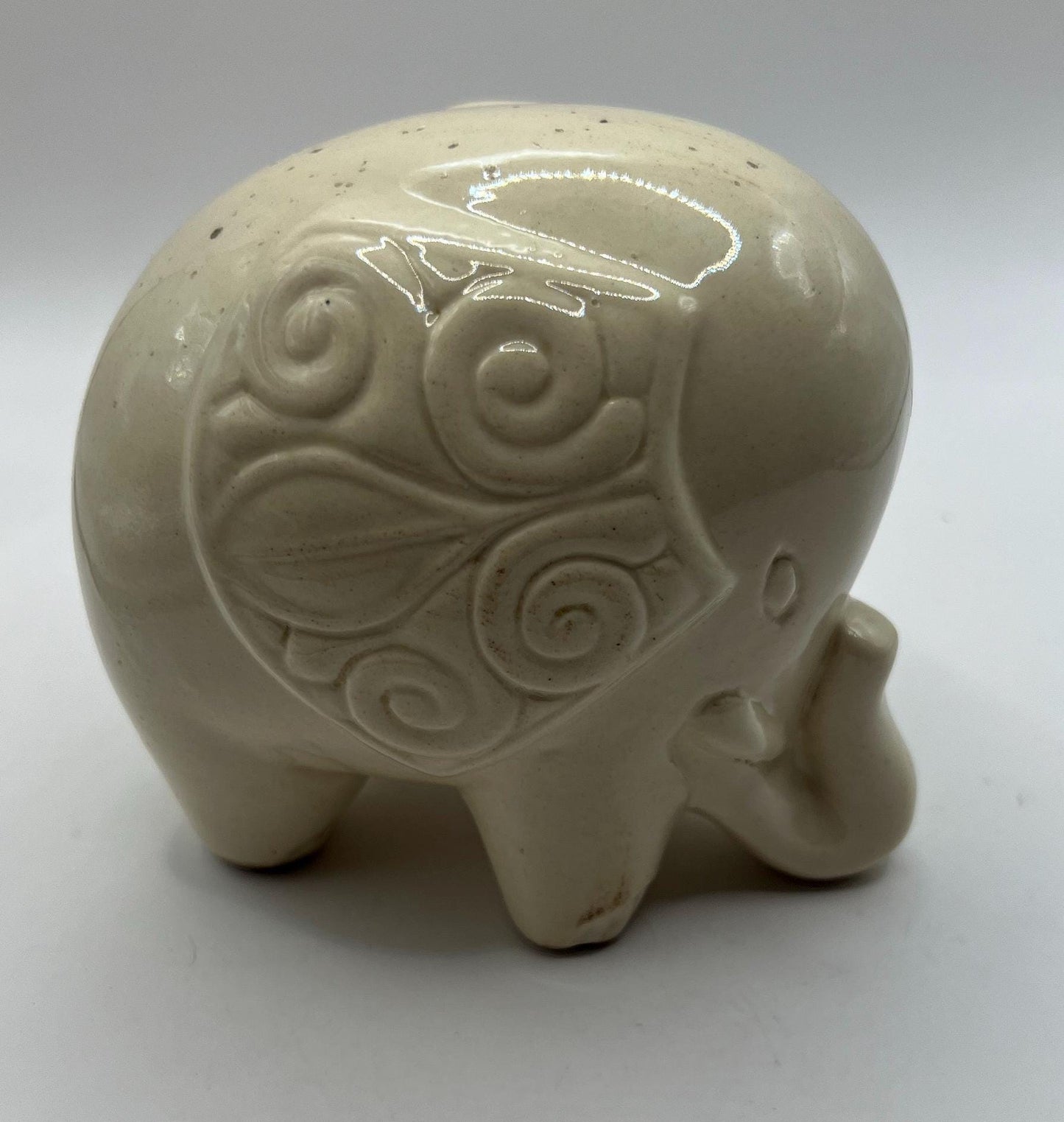 Quirky ceramic elephant figurine with decorated ears.