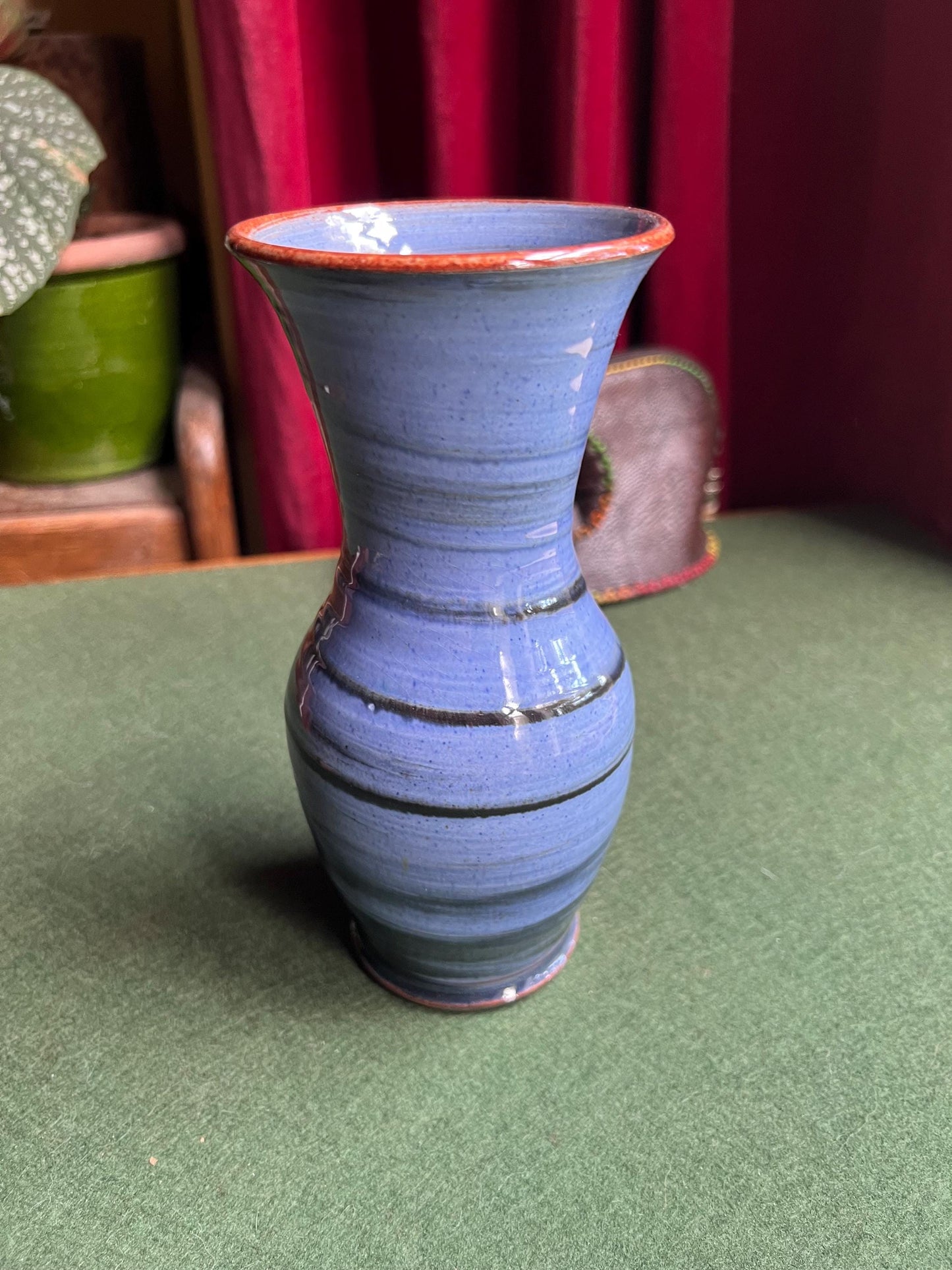 Beautiful vintage studio pottery vase. Blue glaze with black swirl and red rim. Stamped WOLD