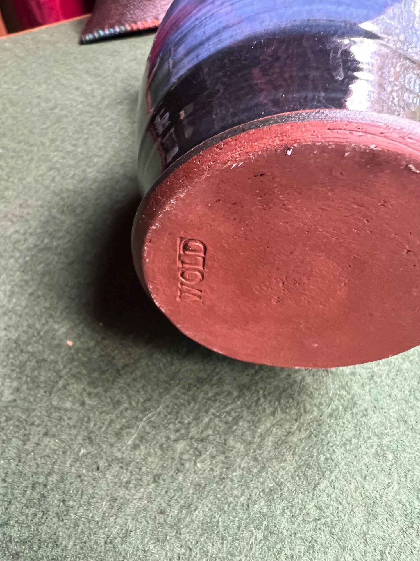 Beautiful vintage studio pottery vase. Blue glaze with black swirl and red rim. Stamped WOLD