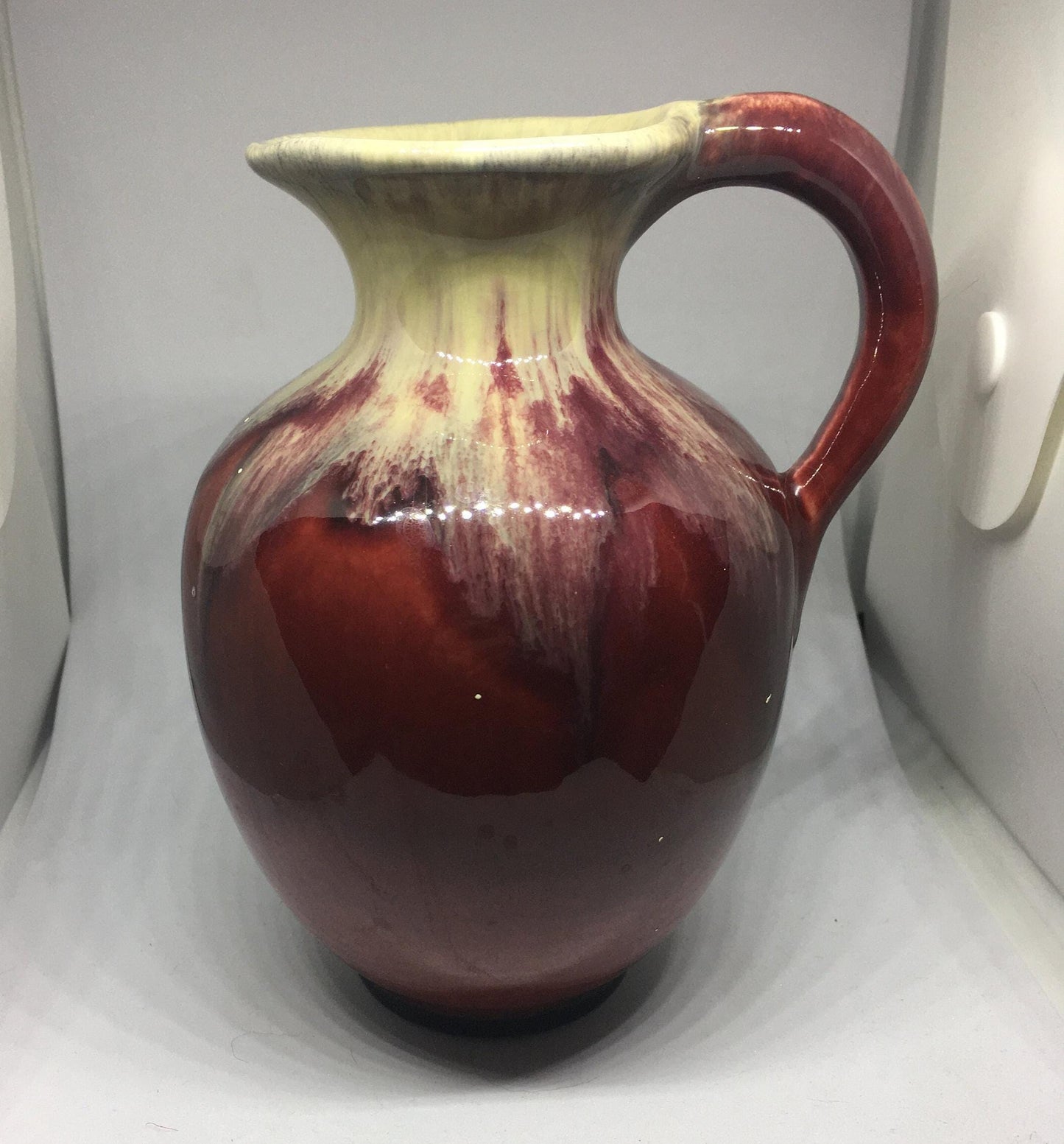 Water jug. German pottery pitcher. Beautiful red and cream drip glazed. Marked Germany.