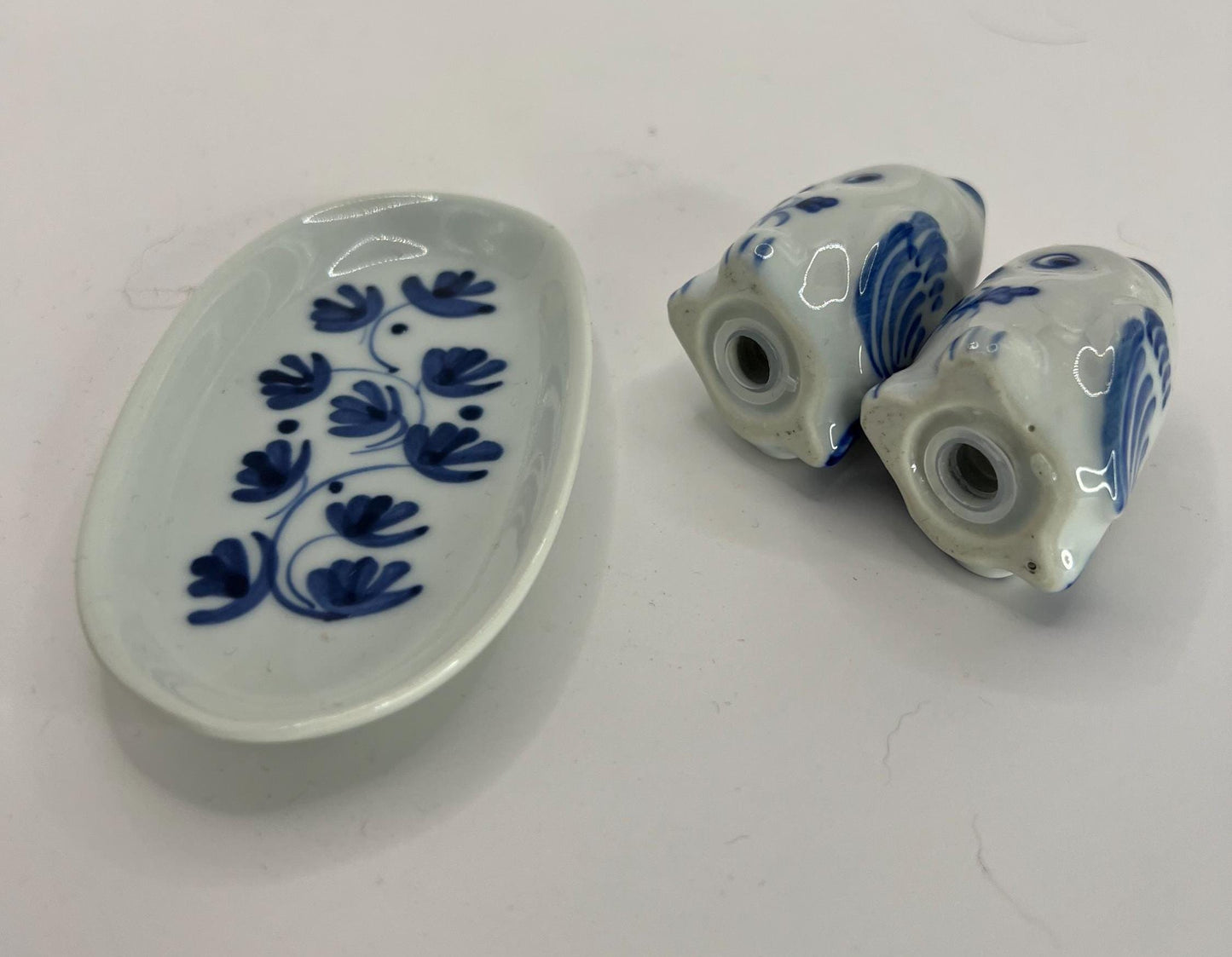 Tiny owl salt and pepper shakers on an oval plate.