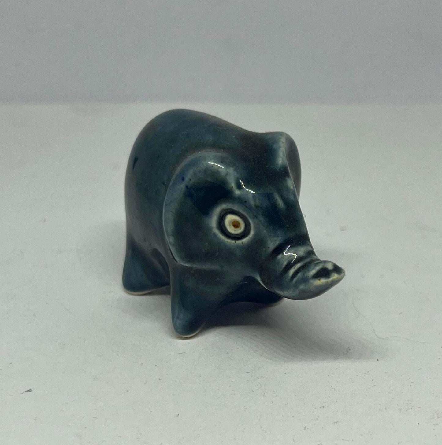 Tiny elephant figurine. Wellow pottery Blue green glaze stylised baby elephant.