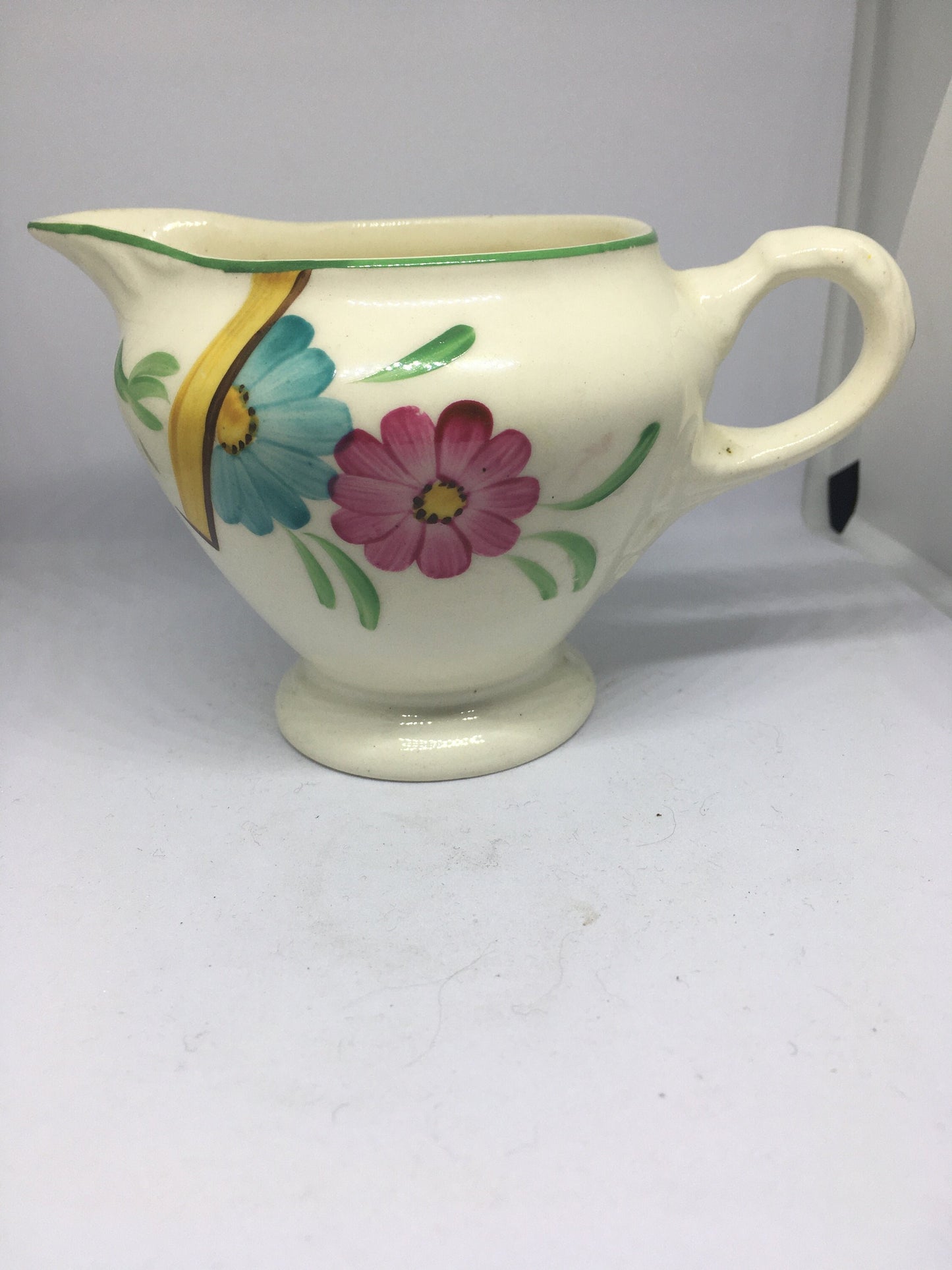 Ceramic hand painted milk jug. Stamped Ainsley England.