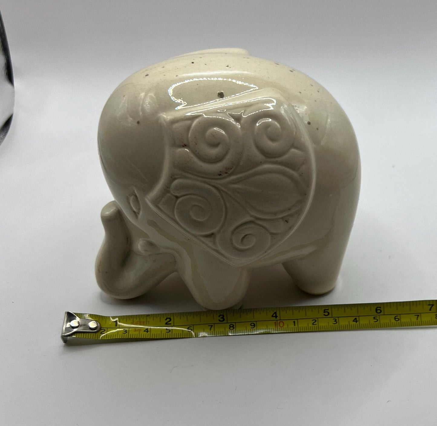 Quirky ceramic elephant figurine with decorated ears.