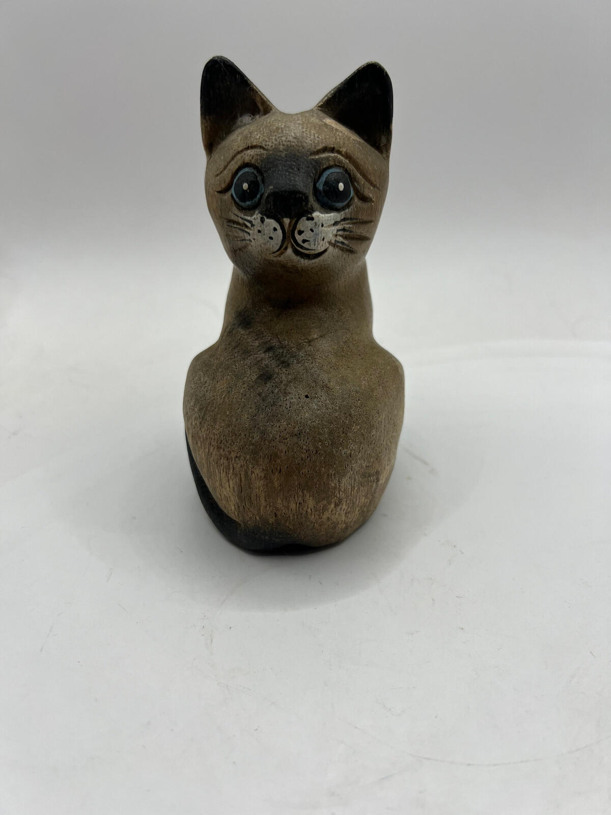 Vintage hand carved wooden quirky cat kitten figurine looking over its shoulder.