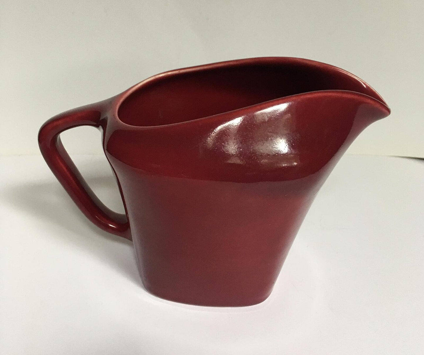 Deep red glazed gravy custard serving jug. Stamped South Seas JG Meakin.
