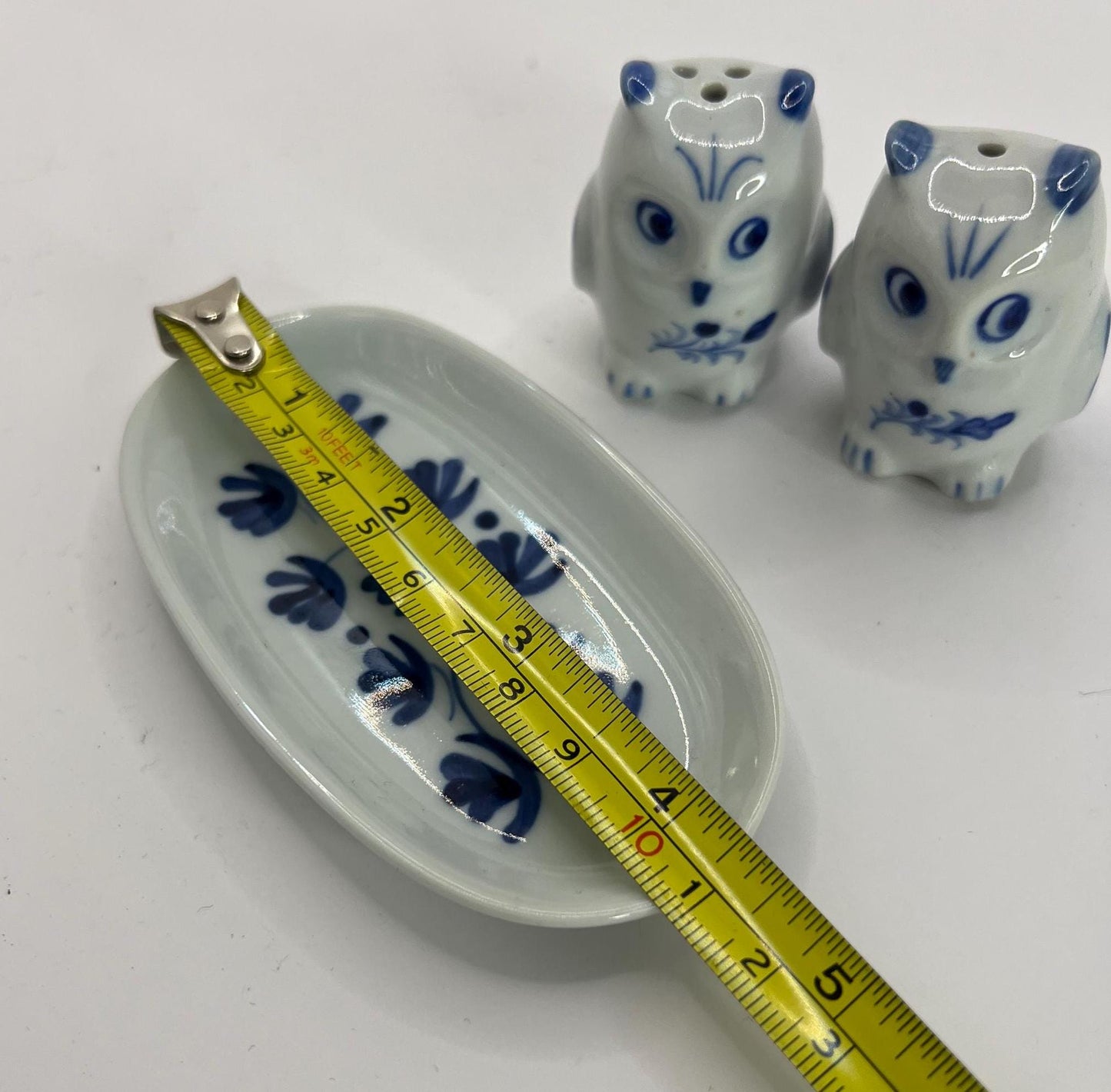 Tiny owl salt and pepper shakers on an oval plate.