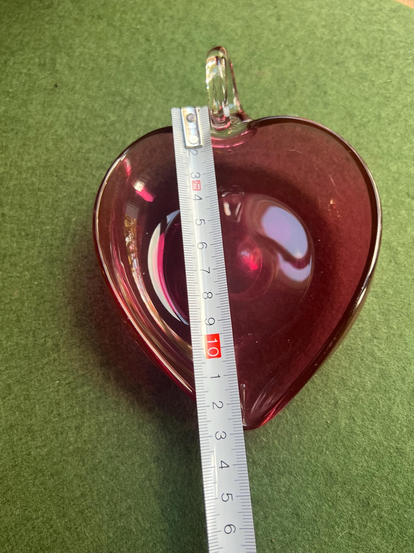 Hand blown cranberry glass heart shaped trinket dish. Applied clear handle.