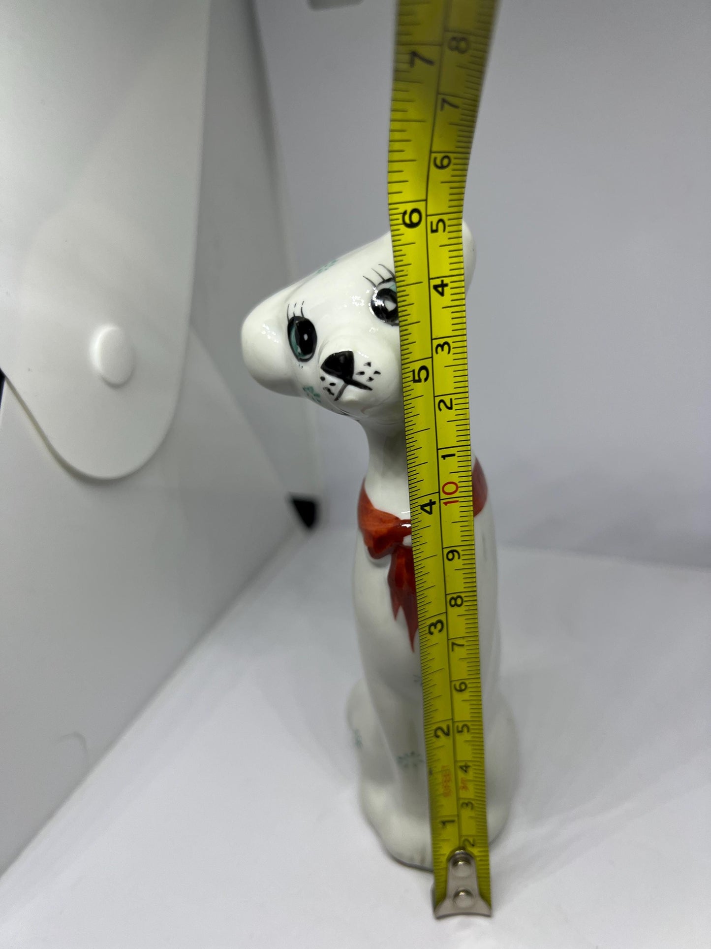 White doe eyed dog with flower spots and red scarf.