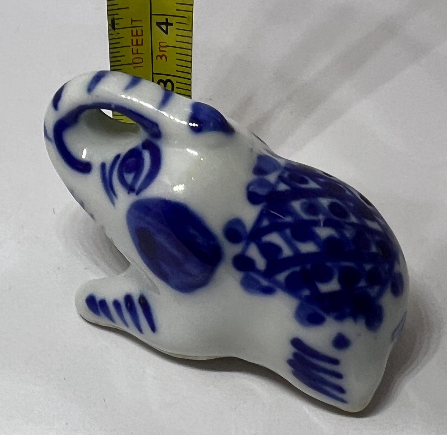Blue white ceramic elephant figurine. Lucky trunk up sitting elephant ornament.